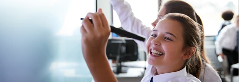 Image of young people smiling while writing